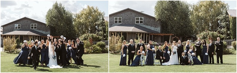 Premier Snohomish & Seattle Wedding Photographer | GSquared Weddings Photography A wedding party poses on a grassy lawn in front of a house in Snohomish; bridesmaids wear navy dresses, groomsmen wear black suits, and the group celebrates with raised bouquets and joyful expressions. 47.9129° N, 122.0982° W | Serving Snohomish, Seattle , Orlando & Beyond