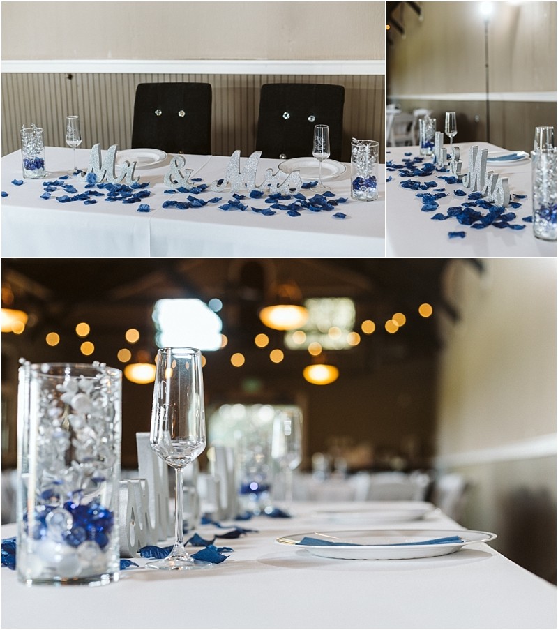 Premier Snohomish & Seattle Wedding Photographer | GSquared Weddings Photography A decorated Snohomish wedding reception table with a “Mr & Mrs” sign, blue rose petals, glass vases with white and blue accents, champagne flutes, and plates set for guests. Warm lights glow in the background of this Seattle celebration. 47.9129° N, 122.0982° W | Serving Snohomish, Seattle , Orlando & Beyond