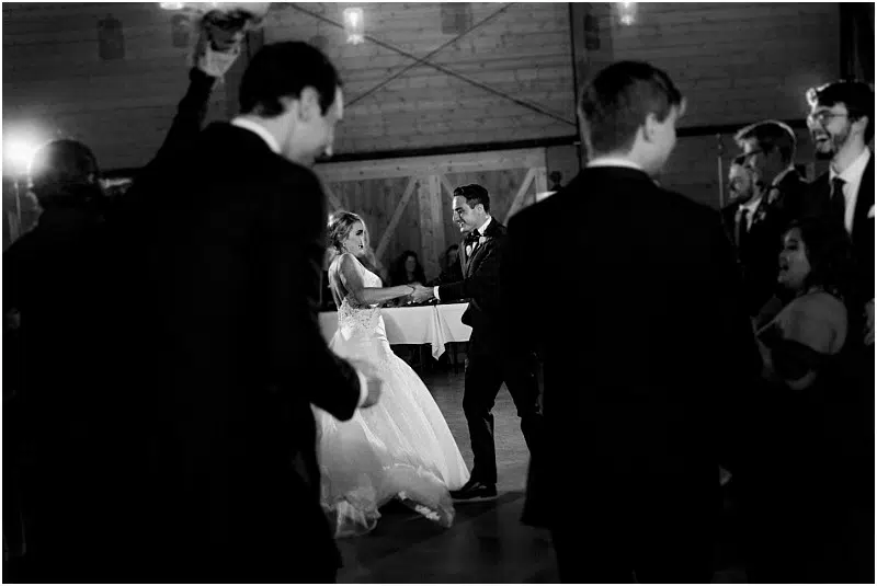 Premier Snohomish & Seattle Wedding Photographer | GSquared Weddings Photography A bride and groom dance together in the center of a dimly lit room, surrounded by guests watching them. This black and white photo captures a classic, romantic atmosphere at their unforgettable Snohomish Seattle wedding. 47.9129° N, 122.0982° W | Serving Snohomish, Seattle , Orlando & Beyond