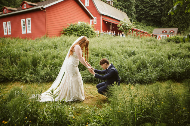 First look between bride and groom at Marionfield Farm red barn in the tall grass