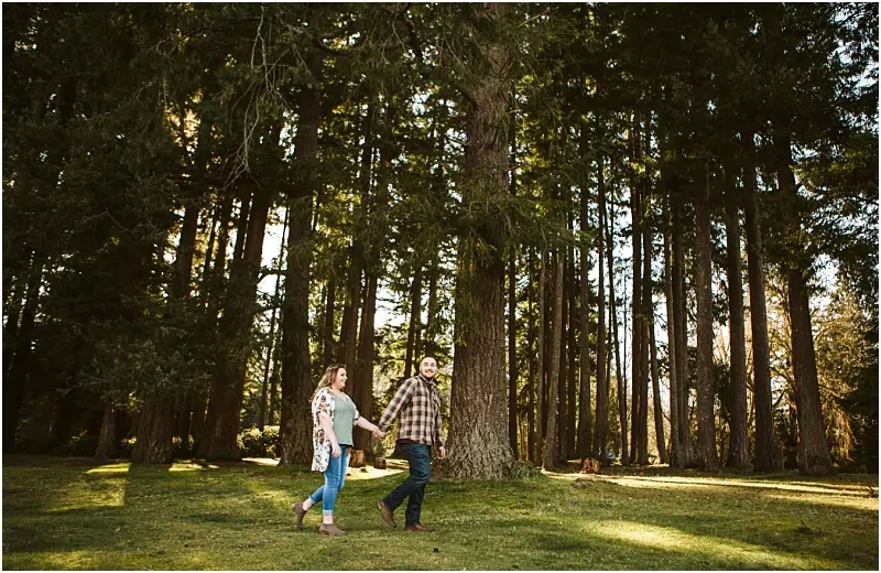 couple walking in the forest during a spring engagement session at lake wilderness in maple valley wa