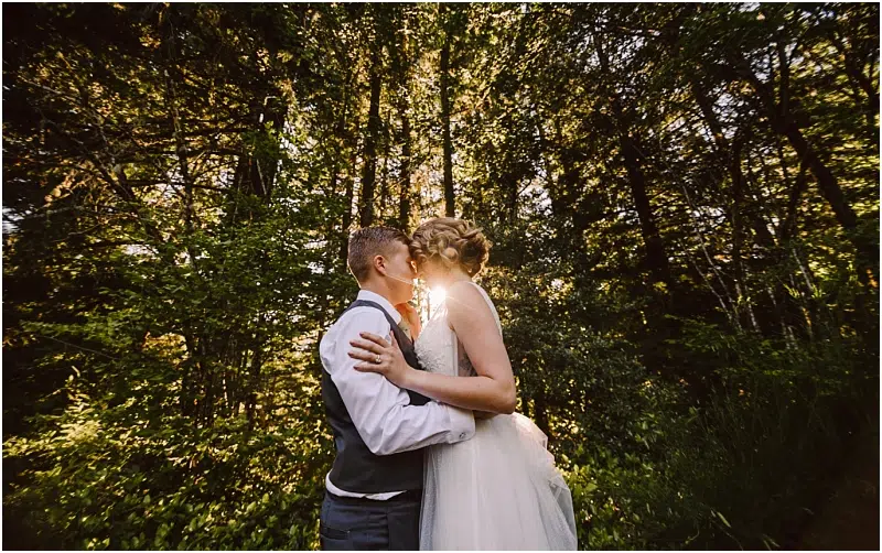 redmond wedding couple kissing at sunset with trees behind them