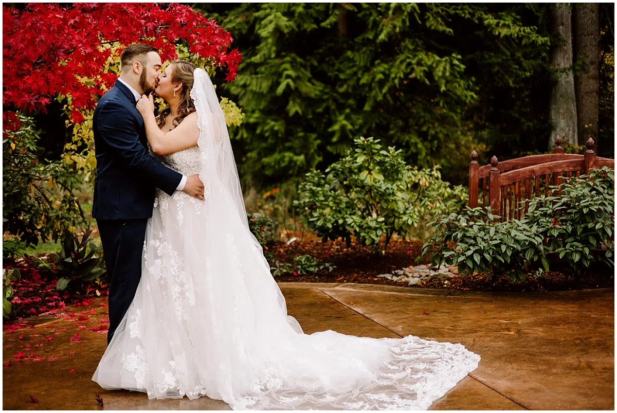 Chateau Wedding in Maple Valley with the red and orange fall leaves and a groom in a blue suit