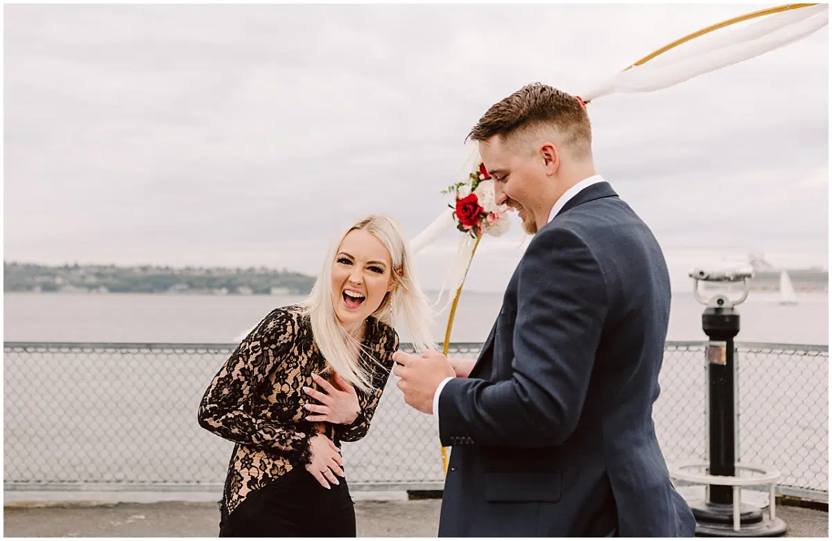 seattle proposal on pier 70 man and woman with puget sound and ferries behind them wedding proposal near the olympic sculpture park