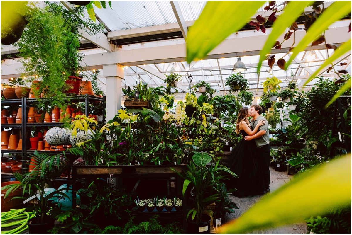 Christianson Nursery engagement session bride in black formal gown among nursery plants