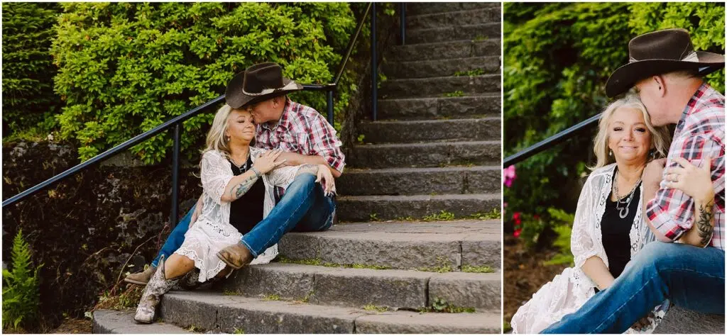 Snohomish Wedding Photographer GSquared Weddings A couple in Western attire sits on stone steps outdoors. The woman, wearing a white lace cardigan and cowboy boots, leans against the man, who is in a plaid shirt and cowboy hat. Green foliage surrounds them on a sunny day. Serving Seattle, Snohomish and Orlando