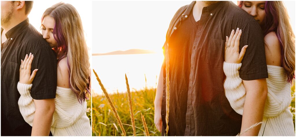 Snohomish Wedding Photographer GSquared Weddings A couple stands in a sunlit field by a lake during sunset. The woman, wearing a white sweater, embraces the man from behind, resting her head on his shoulder. Tall grass sways around them, and the sun casts a warm glow over the scene. Serving Seattle, Snohomish and Orlando