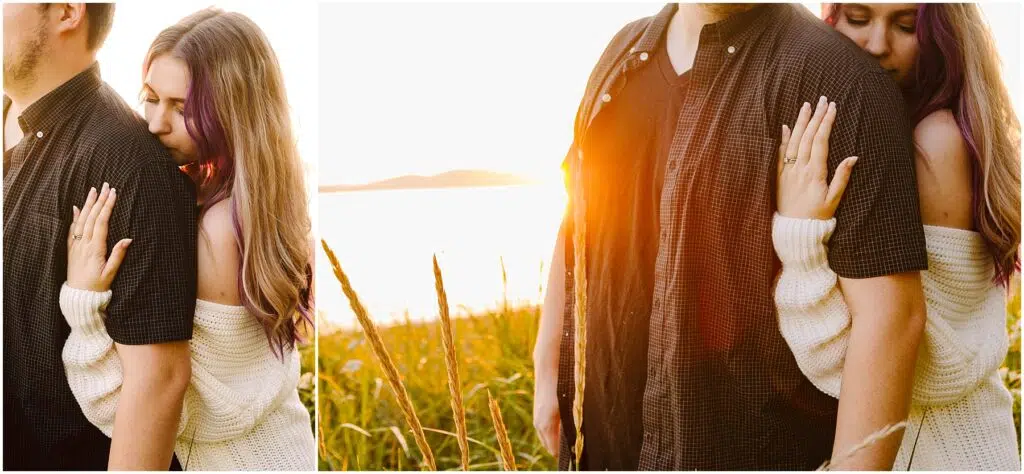 Snohomish Wedding Photographer GSquared Weddings A couple stands in a sunlit field by a lake during sunset. The woman, wearing a white sweater, embraces the man from behind, resting her head on his shoulder. Tall grass sways around them, and the sun casts a warm glow over the scene. Serving Seattle, Snohomish and Orlando
