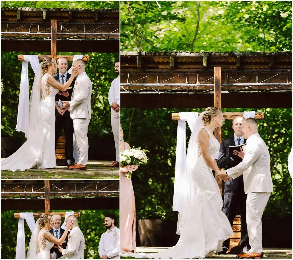 Snohomish Wedding Photographer GSquared Weddings A bride and groom exchange vows in an outdoor wedding ceremony. The bride is wearing a white dress, and the groom is in a light suit. They are standing under a wooden arbor decorated with white fabric, surrounded by lush greenery. Serving Seattle, Snohomish and Orlando