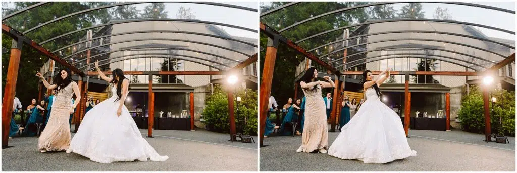 Snohomish Wedding Photographer GSquared Weddings Two women dancing outdoors under a clear canopy. One wears a white wedding gown and the other a light-colored, embellished dress. In the background, guests are seated, watching the performance amid greenery and a building with large windows. Serving Seattle, Snohomish and Orlando