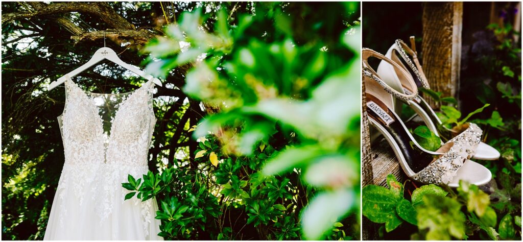 Snohomish Wedding Photographer GSquared Weddings A bridal gown with intricate lace details hangs from a tree branch, surrounded by lush green foliage. Beside it, sparkling high-heeled shoes rest on a wooden surface, partially covered by greenery. Serving Seattle, Snohomish and Orlando
