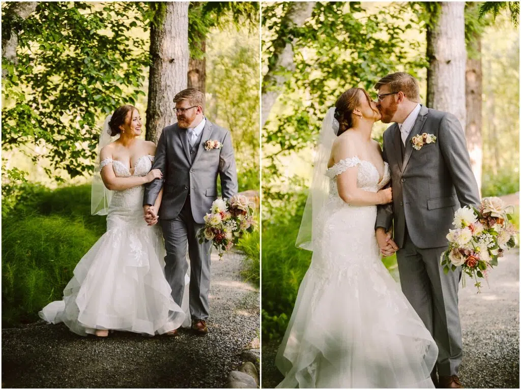 Snohomish Wedding Photographer GSquared Weddings A bride and groom in formal attire share a kiss and walk hand in hand on a wooded path. The bride holds a bouquet of flowers and wears a white gown, while the groom wears a gray suit. Sunlight filters through the trees, creating a serene backdrop. Serving Seattle, Snohomish and Orlando