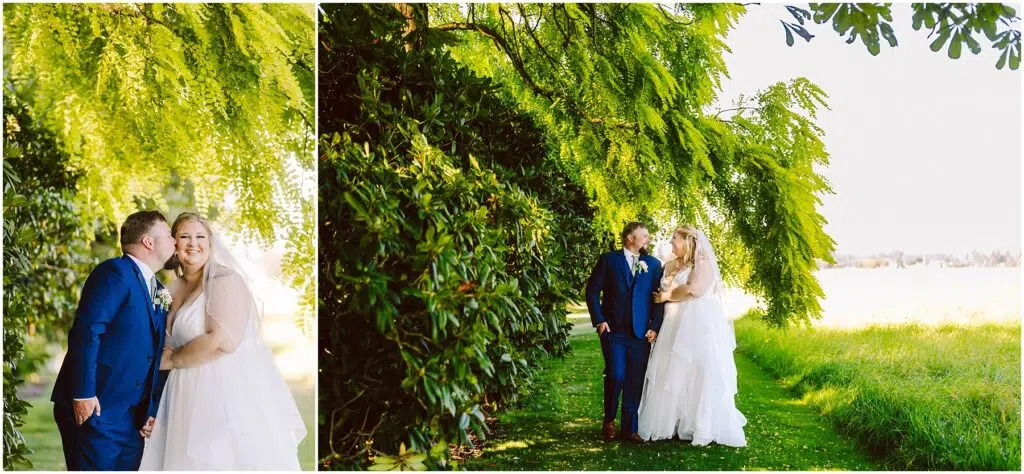 Snohomish Wedding Photographer GSquared Weddings A couple in wedding attire stands under a large, leafy tree, surrounded by greenery. The groom wears a blue suit, and the bride wears a white gown. They are smiling, with the groom kissing the brides cheek in one image. Sunlight filters through the leaves. Serving Seattle, Snohomish and Orlando