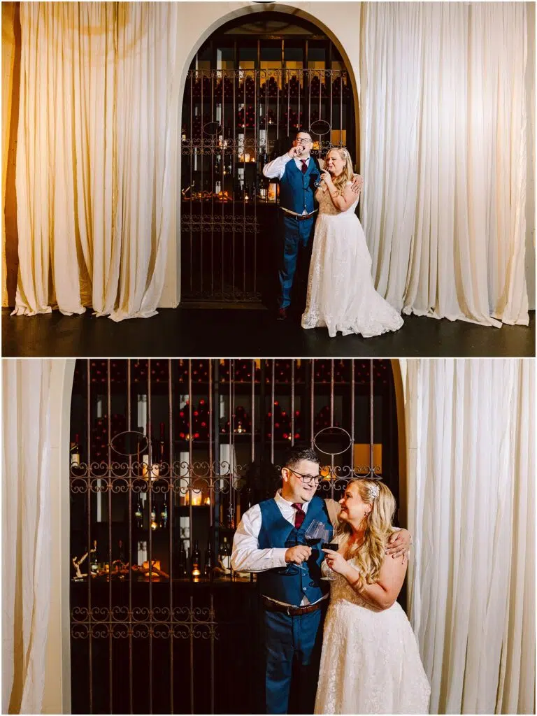Snohomish Wedding Photographer GSquared Weddings A couple in formal attire stands in front of a decorative gate. The man is in a blue suit, playfully posing, and the woman in a white dress, smiling and gesturing towards him. They are surrounded by elegant white curtains. Serving Seattle, Snohomish and Orlando