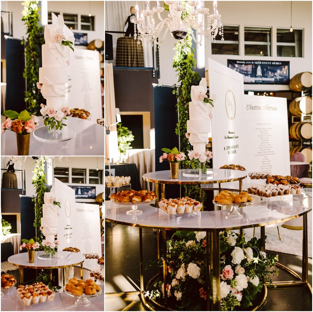 Snohomish Wedding Photographer GSquared Weddings A luxurious display features a tall white wedding cake adorned with white flowers. Surrounding it are trays of pastries on a tiered, gold-accented table. The backdrop includes greenery, chandeliers, and a sign with elegant script. Serving Seattle, Snohomish and Orlando