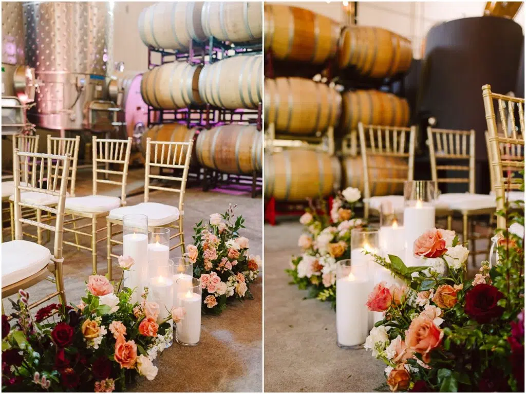 Snohomish Wedding Photographer GSquared Weddings Rows of gold chairs are arranged indoors beside large wine barrels. Floral arrangements with red, pink, and orange flowers, accompanied by lit candles, decorate the aisle. The setting has a warm and inviting atmosphere. Serving Seattle, Snohomish and Orlando