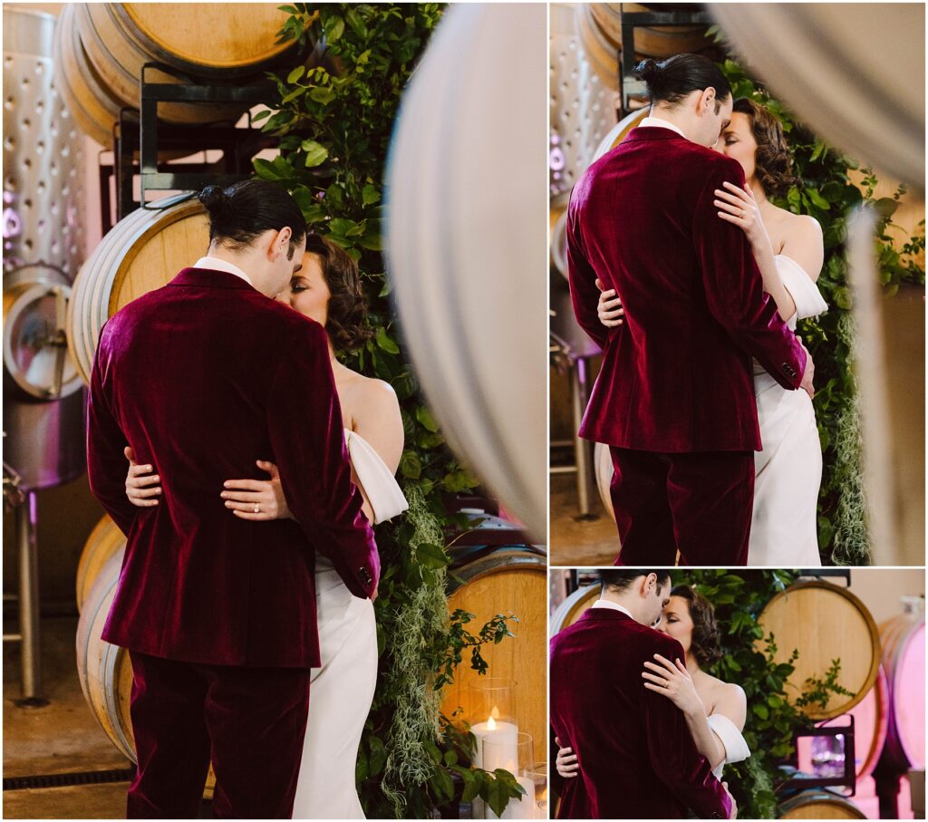 Snohomish Wedding Photographer GSquared Weddings A couple shares an intimate moment in front of wine barrels. The man wears a burgundy suit, while the woman is in a white dress. They embrace closely, surrounded by greenery and soft lighting. Serving Seattle, Snohomish and Orlando