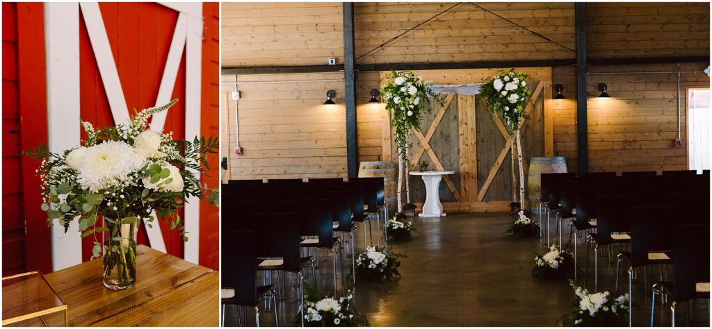 Snohomish Wedding Photographer GSquared Weddings A wooden barn interior set up for a wedding. The aisle is lined with floral arrangements, leading to an altar with a white table and lush greenery. On the left, a close-up of a vase with a white floral bouquet against a red barn door. Serving Seattle, Snohomish and Orlando