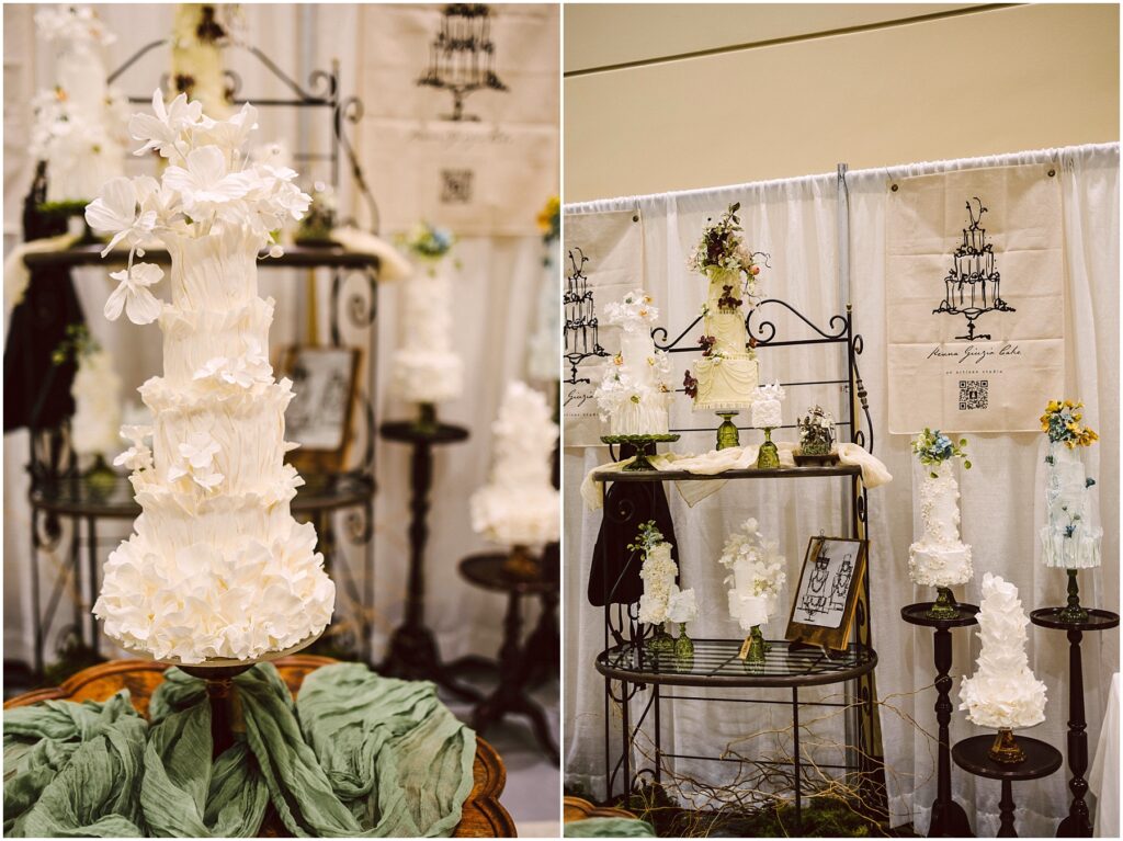 Snohomish Wedding Photographer GSquared Weddings Tall, intricately designed white wedding cakes adorned with delicate floral decorations are displayed on elegant metal stands. The setup includes green fabric accents and framed artwork against a backdrop featuring cake illustrations. Serving Seattle, Snohomish and Orlando