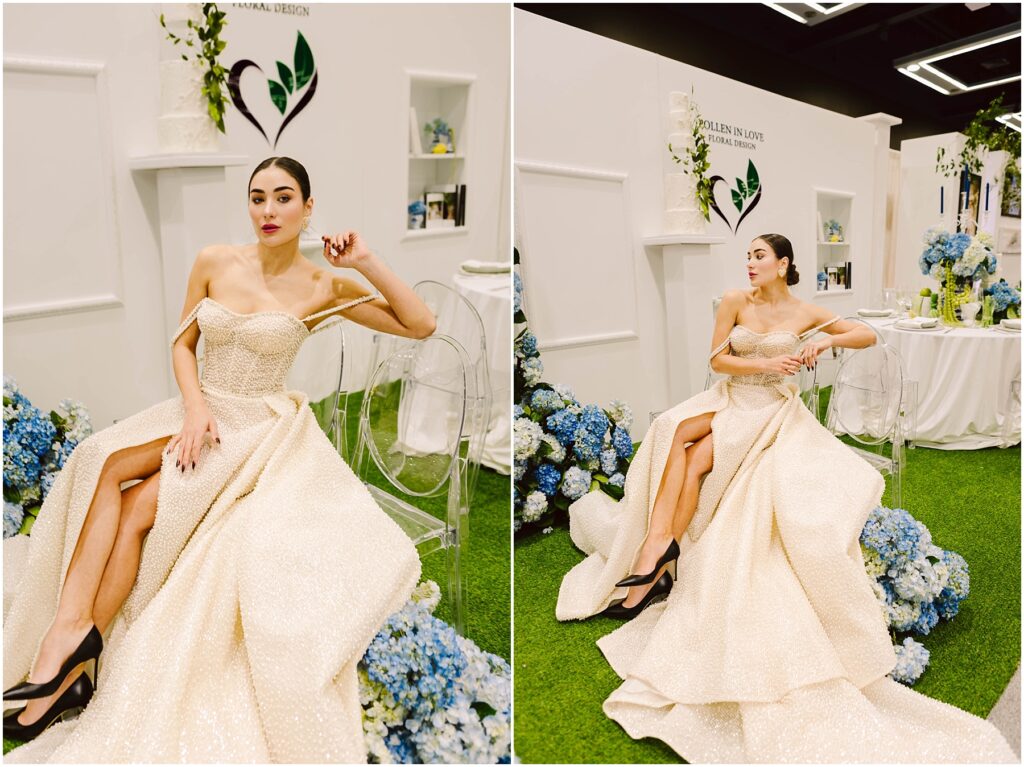 Snohomish Wedding Photographer GSquared Weddings A woman in an elegant cream gown with high slits poses gracefully on a transparent chair. The setting features white walls with floral arrangements and blue hydrangeas, creating a sophisticated ambiance. Serving Seattle, Snohomish and Orlando