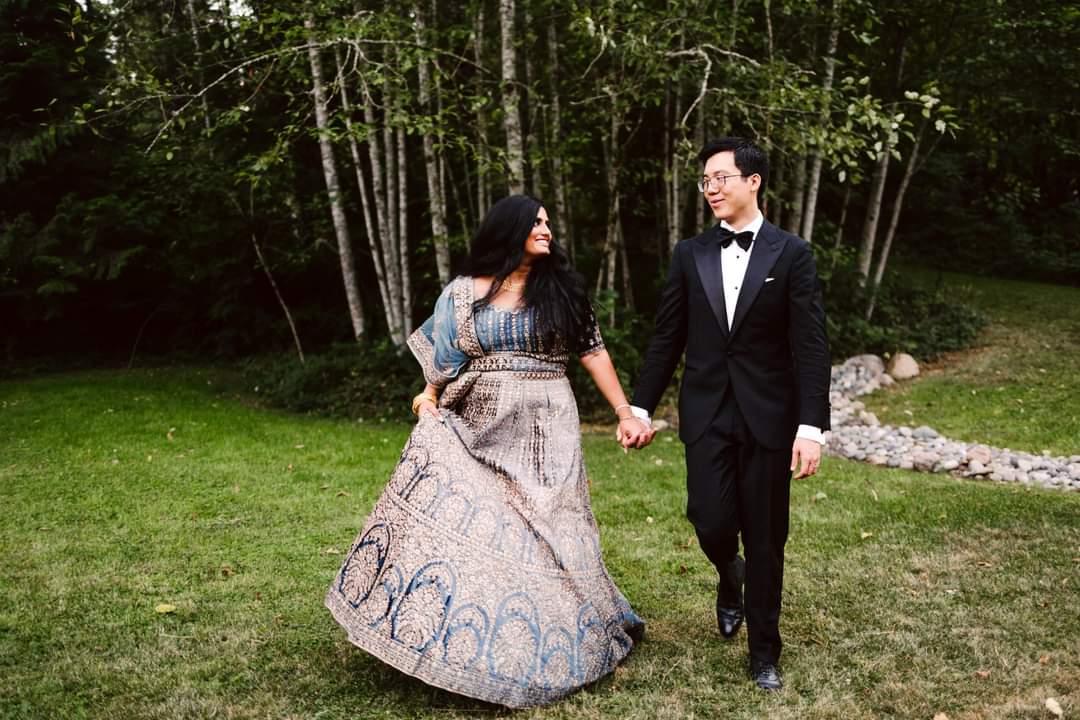Snohomish Wedding Photographer GSquared Weddings A couple strolls hand in hand on a grassy field seemingly posing for a timeless photo The woman wears a patterned dress with a blue top while the man sports a black tuxedo with a bow tie Trees stand majestically in the background as they smile warmly at each other Serving Seattle Snohomish and Orlando Snohomish Wedding Photographer GSquared Weddings A couple strolls hand in hand on a grassy field seemingly posing for a timeless photo The woman wears a patterned dress with a blue top while the man sports a black tuxedo with a bow tie Trees stand majestically in the background as they smile warmly at each other Serving Seattle Snohomish and Orlando