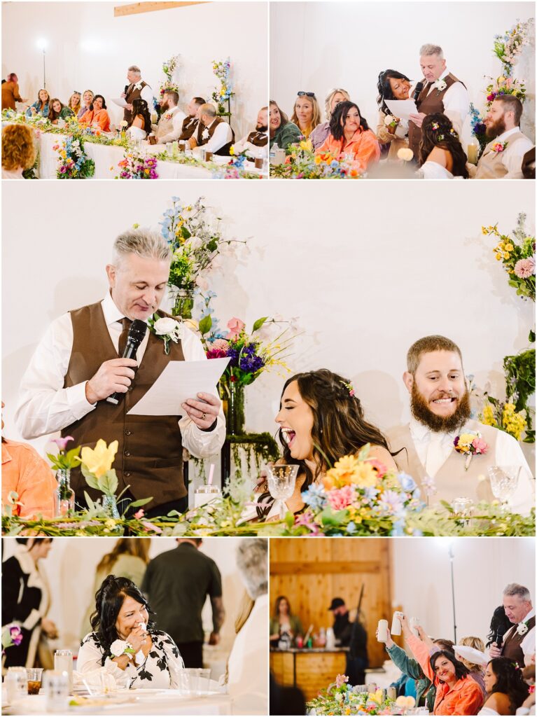 Snohomish Wedding Photographer GSquared Weddings A lively wedding scene unfolds in Machias, with guests seated at tables adorned with colorful flowers. A man in a vest speaks into a microphone, while the couple smiles beside him. The room is filled with people joyously celebrating the occasion. Serving Seattle, Snohomish and Orlando