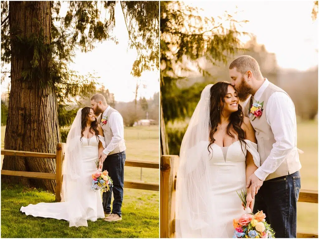 Snohomish Wedding Photographer GSquared Weddings A bride and groom stand outdoors by a wooden fence in Machias, surrounded by greenery. The bride wears a white dress and holds a vibrant bouquet. The groom, in a vest and jeans, gently kisses her forehead. They both look content and happy. Serving Seattle, Snohomish and Orlando