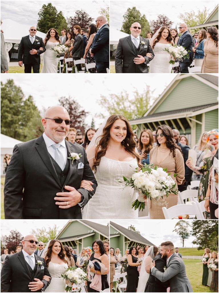 Snohomish Wedding Photographer GSquared Weddings In the charming setting of Port Gamble, a bride in a white dress and a man in a dark suit walk down an outdoor aisle, graced by the warmth of a beautiful summer wedding. Guests watch, some seated and others standing, as the bride carries a bouquet of white flowers to meet someone for an embrace at the end. Serving Seattle, Snohomish and Orlando