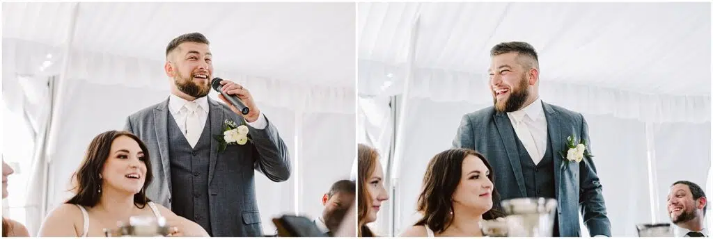 Snohomish Wedding Photographer GSquared Weddings At a summer wedding in Port Gamble, a man in a gray suit and white shirt stands under a white tent, holding a microphone. He speaks with warmth and smiles at the seated woman with long dark hair, who listens intently. Around them, guests join in the celebration, adding to the joyous atmosphere. Serving Seattle, Snohomish and Orlando