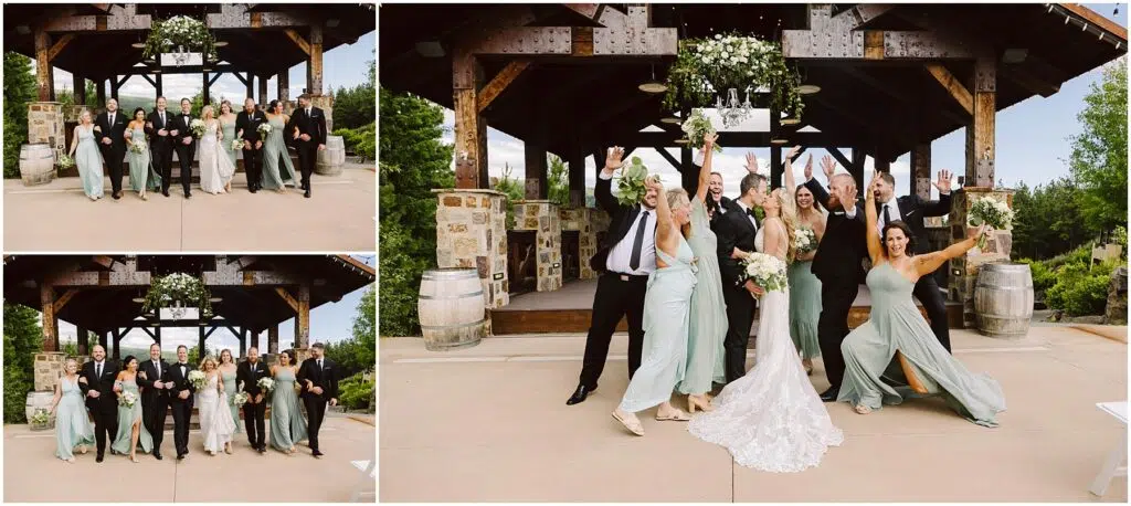 Snohomish Wedding Photographer GSquared Weddings A wedding party poses joyfully in front of a wooden pavilion at the winery. The bride in a white dress is surrounded by bridesmaids in sage green and groomsmen in black suits. Everyone raises their arms in celebration against a lush backdrop of greenery. Serving Seattle, Snohomish and Orlando