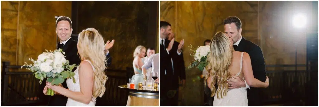 Snohomish Wedding Photographer GSquared Weddings A couple in formal attire shares a joyful moment at a winery celebration. The man, wearing a tuxedo, smiles broadly with open arms, while the woman, in a white dress holding a bouquet, looks at him. They are surrounded by applauding guests amid the rustic charm of the vineyard. Serving Seattle, Snohomish and Orlando