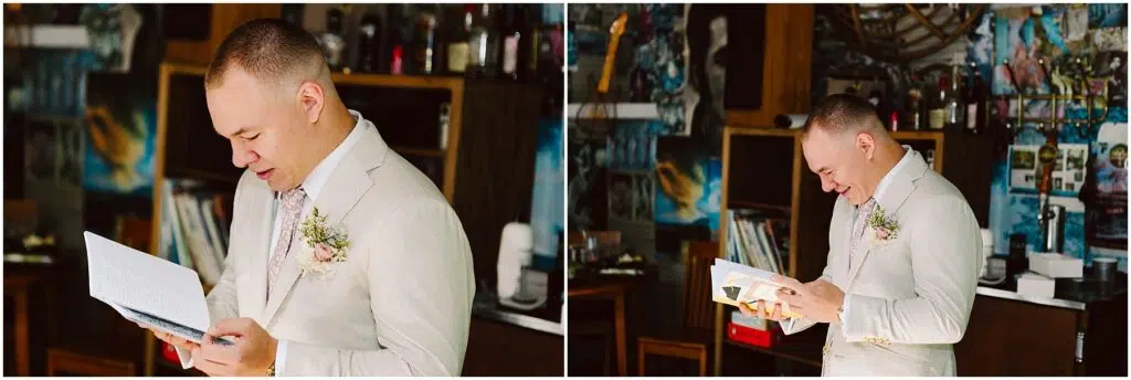 Snohomish Wedding Photographer GSquared Weddings A man in a light suit, adorned with a boutonniere, gazes thoughtfully at a letter and then at a gift. He stands in a room reminiscent of Snohomish charm, filled with eclectic decorations and shelves brimming with bottles and books. Serving Seattle, Snohomish and Orlando