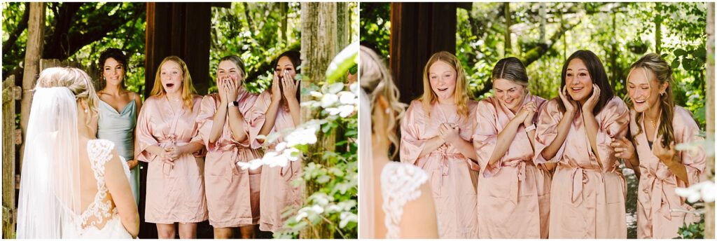 Snohomish Wedding Photographer GSquared Weddings A bride in a wedding dress stands before five bridesmaids wearing matching pink robes in picturesque Snohomish. The bridesmaids react joyfully amid the lush greenery, their excitement palpable as they gaze upon her. Serving Seattle, Snohomish and Orlando