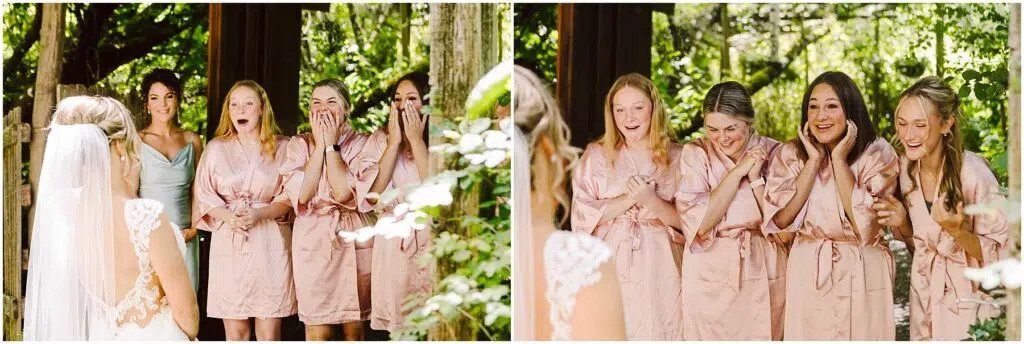 Snohomish Wedding Photographer GSquared Weddings A bride in a wedding dress stands before five bridesmaids wearing matching pink robes in picturesque Snohomish. The bridesmaids react joyfully amid the lush greenery, their excitement palpable as they gaze upon her. Serving Seattle, Snohomish and Orlando